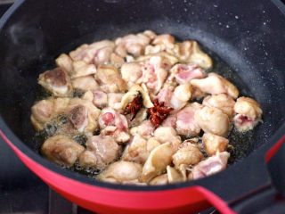 鸡腿肉豆角焖面,油锅烧热后，先炸香八角，再放入鸡腿肉大火快速翻炒变色。