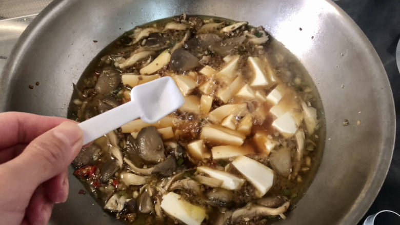 蘑菇炖豆腐,开盖尝下咸淡，根据个人口味补充少许盐