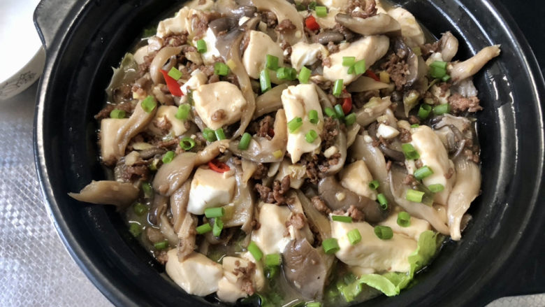 蘑菇炖豆腐,撒上葱末，即可上桌享用了