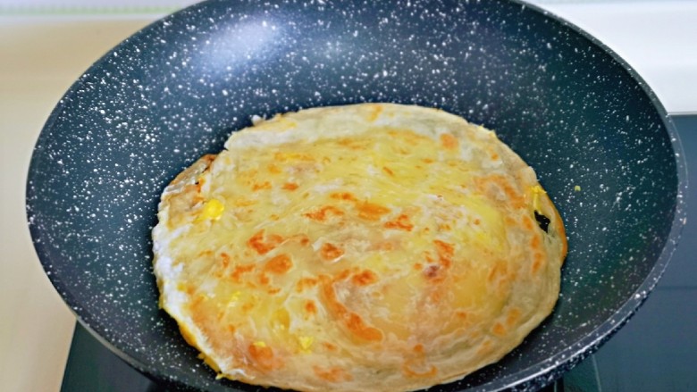 老北京鸡肉卷,翻面，将鸡蛋煎至凝固即可出锅。