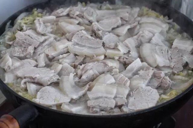 酸菜炖粉条,切好的肉片直接铺到酸菜上，继续小火炖煮二十分钟。