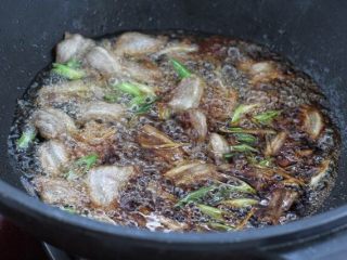 白菜炒木耳,接着放入姜丝和葱花炒香，调入生抽和料酒翻炒均匀。