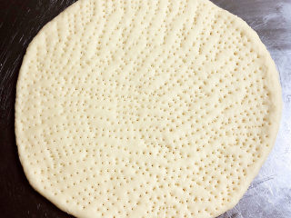 虾仁培根披萨,在饼底上用叉子扎一些小洞。提前预热烤箱，180度预热10分钟。