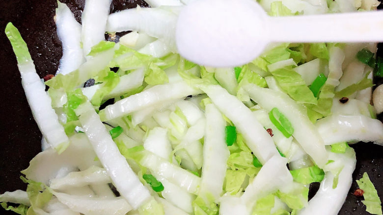 白菜炒木耳,放入盐翻炒均匀。