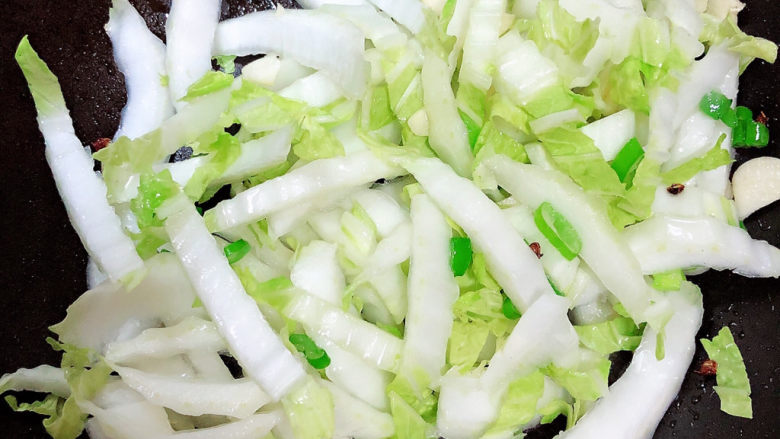 白菜炒木耳,先放入白菜根部翻炒均匀。