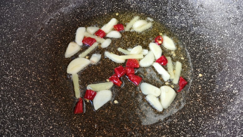 酸菜炖粉条,锅里重新倒油烧热，下入蒜片、姜丝和干红辣椒炒香。