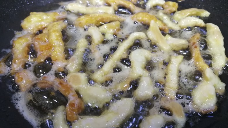 老北京鸡肉卷,平底锅，倒入比炒菜多点的油，油5成热逐条下鸡肉条，文火慢煎。