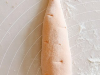 胡萝卜馒头,再用手搓成胡萝卜的样子，用刀划几个痕，做胡萝卜须的样子