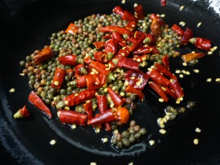 香辣鸡脆骨,另起锅倒油，油热后放入浸泡的干辣椒和花椒，小火慢炒
