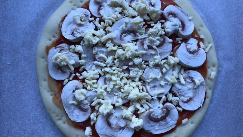 虾仁培根披萨,先铺一层蘑菇片，撒一层芝士。