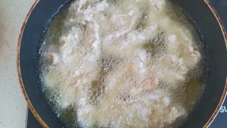 老北京鸡肉卷,锅中烧油，油温6成热，下入鸡肉条中火炸