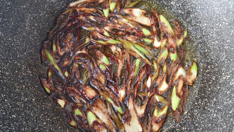 南瓜焖饭,开中火将葱丝炸至深褐色，捞出不要。