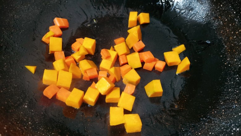 南瓜焖饭,锅里烧热，倒入少许食用油，把胡萝卜放下去，翻炒一会再倒入南瓜丁一起翻炒