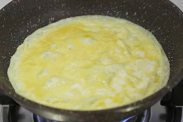 老北京鸡肉卷,用平底锅把鸡蛋液摊成两个薄饼；