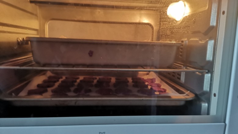 紫薯椰蓉饼干,送入预热好的烤箱，上火180度，下火160度，烤15分钟