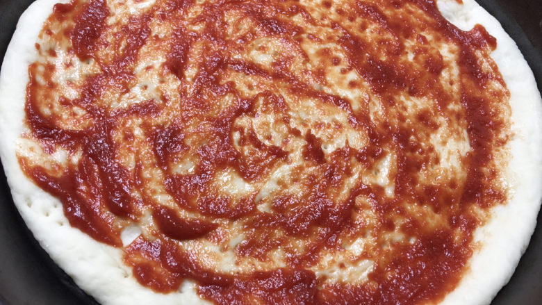 虾仁培根披萨,饼皮上抹上番茄酱