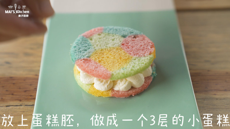 彩虹小蛋糕 ,取一片圆形的蛋糕胚挤上打发好的奶油，放上蛋糕胚，做成一个3层的小蛋糕。