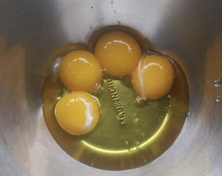 小葱炒鸡蛋,把鸡蛋打入盆中。