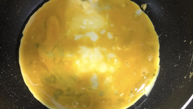 小葱炒鸡蛋,锅中加入适量油，油烧热以后，倒入鸡蛋液。