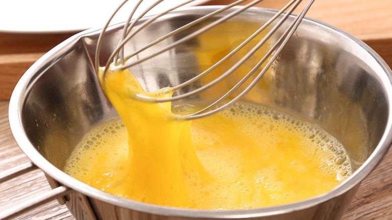 小葱炒鸡蛋,用手动打蛋器搅打鸡蛋。
