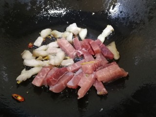 油豆腐烧肉,先放入肥肉，文火煸炒出油脂，再放入瘦肉条，文火翻炒。