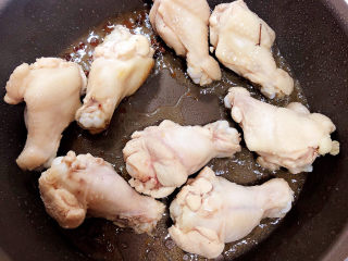 油豆腐烧肉,待白糖融化放入鸡翅根，翻炒均匀。