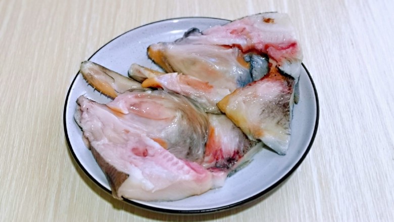 清蒸鸦片鱼,鱼头从中间剪开，一剪二，肉朝上放入盘中。