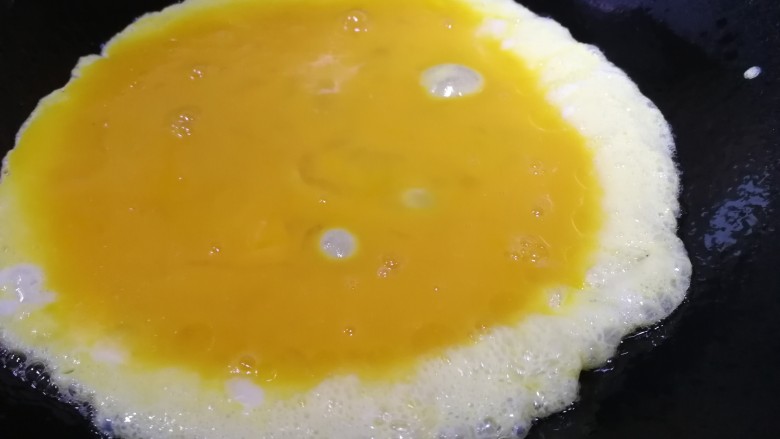 小葱炒鸡蛋,油热倒入蛋液。