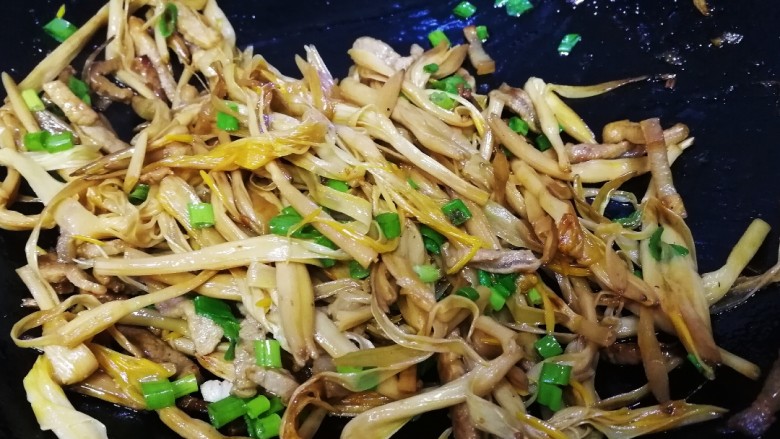 黄花菜炒肉丝,放入葱花翻炒均匀即可。