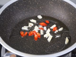 红烧油豆腐,锅里烧热油，爆香蒜和小米辣