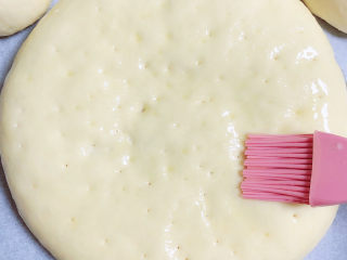 奶酪饼,待面饼发酵至两倍大小，刷上一层黄油。