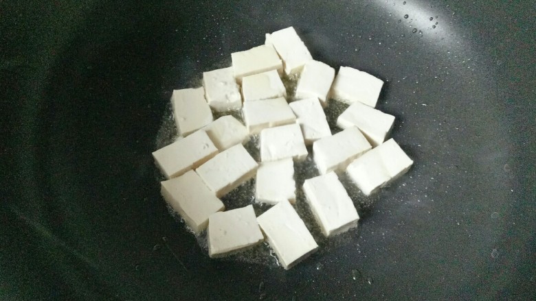 雪菜豆腐,炒锅中加入适量花生油烧热，放入豆腐块