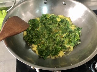 芹菜叶炒鸡蛋,蛋液煎到定型，翻面煎炒到定型，炒散盛出
