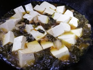 雪菜豆腐,水开放入豆腐，大火煮开，改文火炖15分钟。