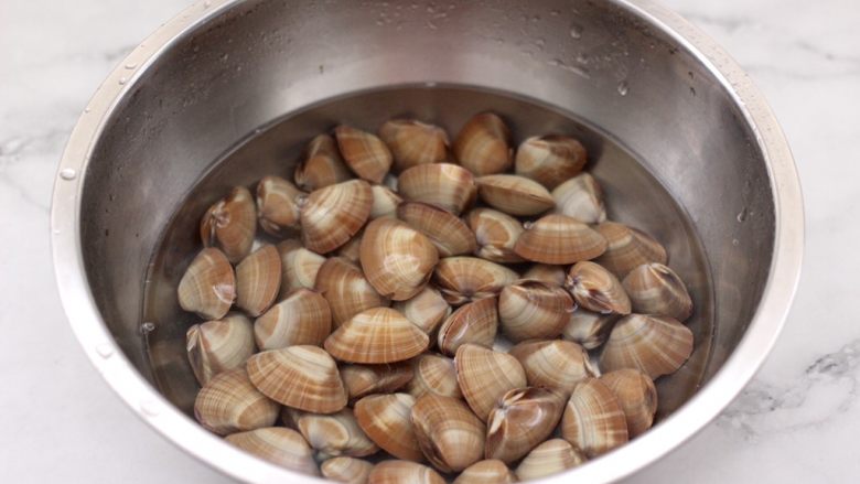 麻辣飞蛤,飞蛤先用清水洗净后，放入盆中加入适量清水和1勺盐，让飞蛤缓出泥沙后洗净备用。