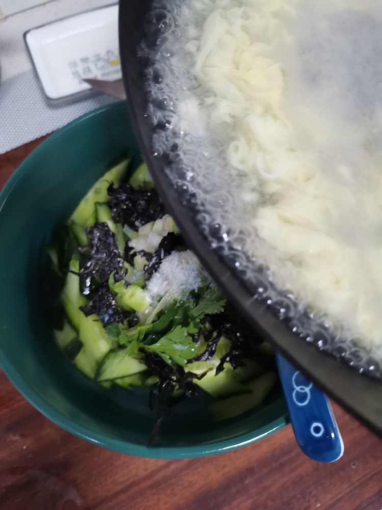 鸡蛋瓜片汤,趁热浇到加了调料的瓜片碗中。