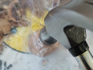 琥珀咸核桃仁,放到一个厚一点的袋子里，用锤子敲碎。这样不容易蹦的哪里都是皮