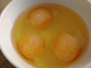 黄花菜炒鸡蛋,鸡蛋打入碗里，加半小勺盐入味。