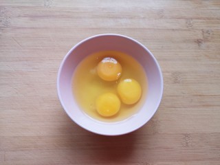 芹菜叶炒鸡蛋,鸡蛋磕入碗里。