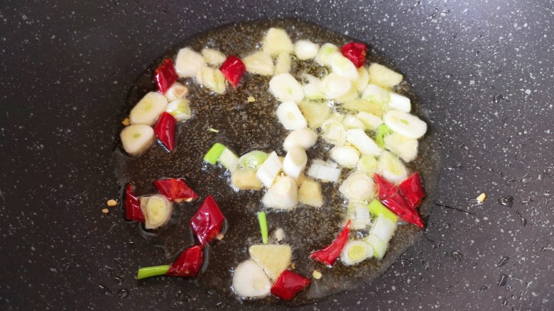 红烧油豆腐,炒锅内倒适量的食用油烧热，下入葱姜蒜和干红辣椒炒香。
