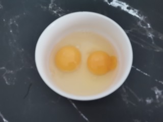 芹菜叶炒鸡蛋,碗中打入鸡蛋