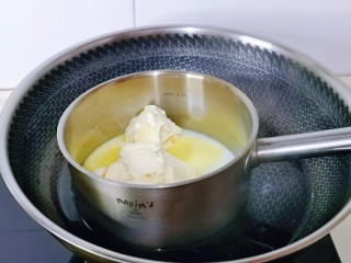 半熟芝士蛋糕,奶油奶酪与牛奶放入耐高温的器具中，隔水融化，一边用手动打蛋器搅拌。