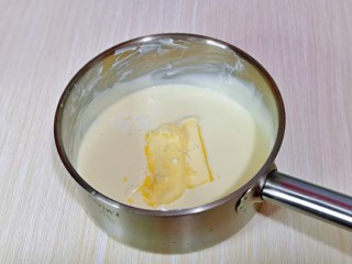 半熟芝士蛋糕,融化至细腻，牛奶与奶酪完全融合，再加入黄油，继续隔水融化，搅拌至黄油与奶酪融合在一起。