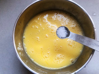 培根炒蛋,加盐调味，搅拌至盐融化