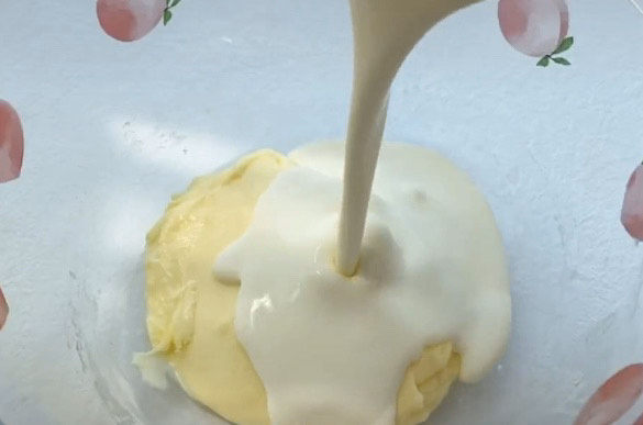 半熟芝士蛋糕,软化好的奶油奶酪里加入奶油40克，翻拌均匀。奶油的加入是必不可少的，这样做出来的半熟芝士更加奶香浓郁