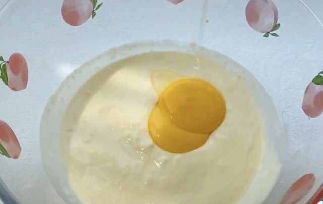 半熟芝士蛋糕,准备的两个<a style='color:red;display:inline-block;' href='/shicai/ 9'>鸡蛋</a>，提前分离出蛋黄和蛋白，两个蛋黄加入，混合均匀