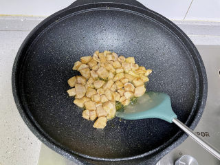 黄瓜炒鸡丁，荤素搭配，清新爽口,锅里热油，下入腌好的鸡肉丁炒至变白。
