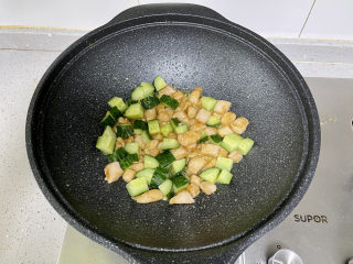 黄瓜炒鸡丁，荤素搭配，清新爽口,加入黄瓜丁翻炒。