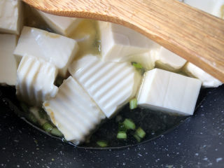 葱油豆腐,轻轻翻动豆腐炒均匀，倒入开水。