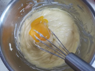 半熟芝士蛋糕,两个蛋黄分两次加入，每次加入后搅拌均匀至顺滑状态再加下一个蛋黄，继续搅拌均匀至顺滑状态